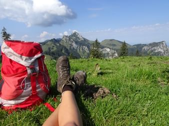 Wanderschuhe und Wanderrucksack vor Bergkulisse