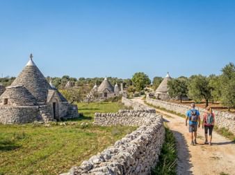 Wanderer die an Steinhäuser vorbei wandern