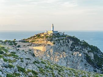 Blick auf den Leuchtturm auf einem felsigen Hügel am Cap de Formentor