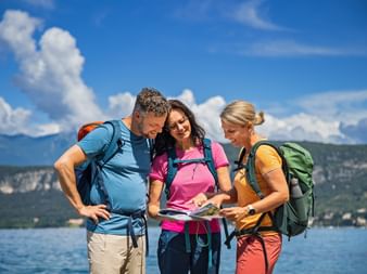 Tour briefing for three hikers with the travel documents in Bardolino