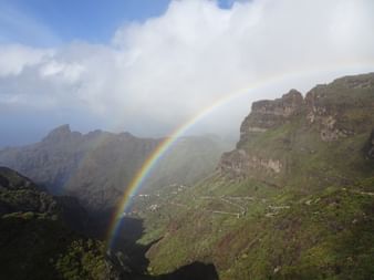 Doppelter Regenbogen vor Felsen