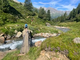 Wanderin beim Überqueren der Holzbrücke am Timmelsjoch