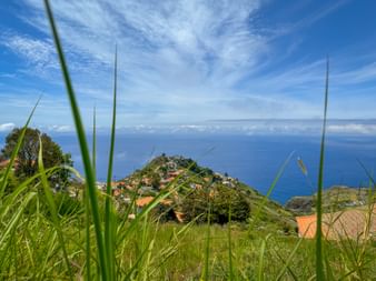 Weitblick über den Atlantik und auf die hügelige Küste von Calheta