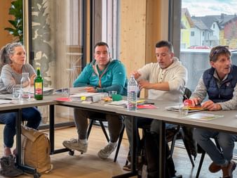 Four people seated at tables during Eurofun Touristik Training Days 2026. Water bottles and materials are on the tables in a bright room.