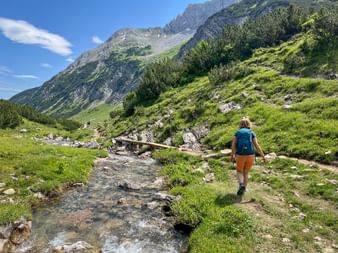 Hiker in the valley with a view of the mountain landscape