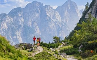 Hikers at the Vršič Pass with panoramic views of the mountains