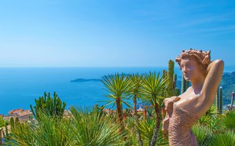 Weitblicke von einer Frauenstatue auf die Palmen, Bergdörfer und das Meer genießen