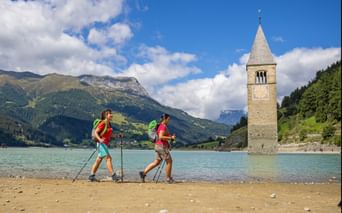 Hikers on the shore of lake Resia