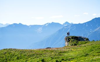 Hikers on a rocky outcrop with a view into the valley
