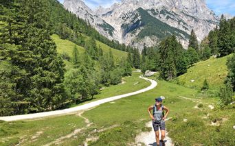 Wanderin im Klausbachtal auf dem Weg zur Bindalm mit Bergpanorama im Hintergrund