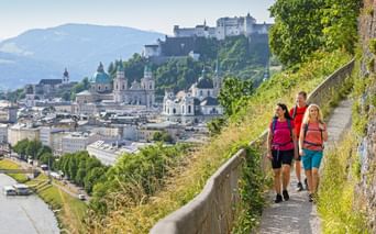 Hikers on the Mönchsberg with Salzburg's old town in the background