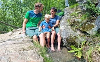 Happy family by a stream in South Tyrol