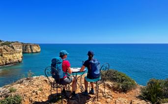 Wanderer an einem schönen Rastplatz mit Meerblick an der Algarve