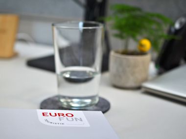 Eurofun Ordner mit Glas und Pflanze im Hintergrund