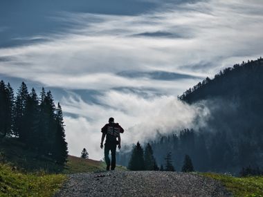 A hiker on the Postalm with a special cloudy atmosphere in the background