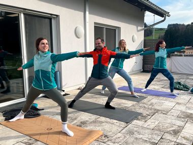 4 Personen beim Yoga auf einer Terrasse