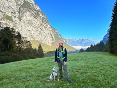 Wanderer mit Hund in den Bergen bei Comano Terme