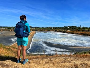Wanderer mit Blick auf das Salzbecken in Fuesta an der Algarve