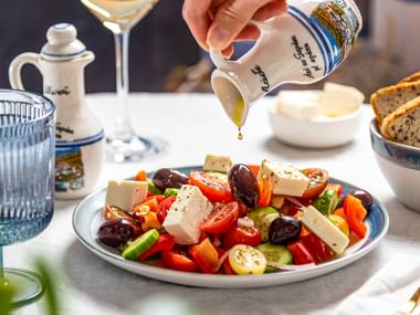 Teller mit einem griechischen Salat mit Tomaten, Oliven, Schafskäse, Zwiebel, Gurken, Olivenöl