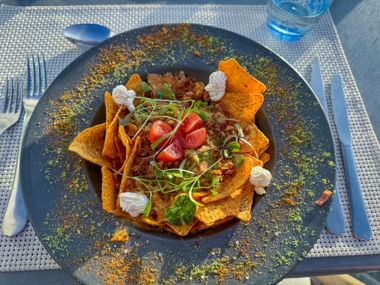 Nachos auf Teller mit bunter Garnierung