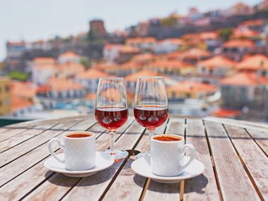 Two glasses of Madeira wine and two cups of coffee