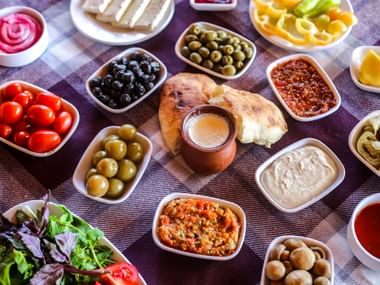 Aufstriche, Oliven, Champignons, Tomaten, Salat, Paprika auf einem Tisch in Schüsseln