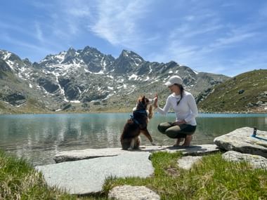 Wanderer und Hund pausieren vor dem See