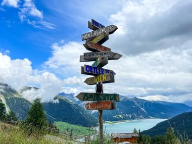 Signpost with a view of Lake Reschen