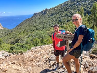 Hiking couple with signpost ‘Cala Goloritze’