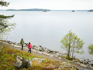 Two hikers on a path next to the lake