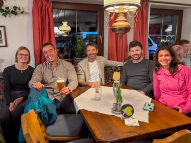 Five people sitting at a wooden table in a cozy restaurant during Eurofun Touristik Training Days 2026 dinner, smiling at the camera.