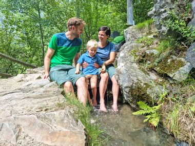 Wanderrast einer Familie an einem Bach an einem Südtiroler Waalweg