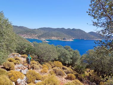 Wanderer, steiniger Weg, Ausblick auf das azurblaue Meer, sonniges Wetter