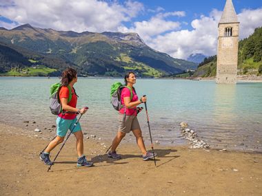 Wanderer am Reschensee in Südtirol