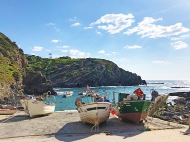 Fishing boats in bay, high cliffs, sunny weather