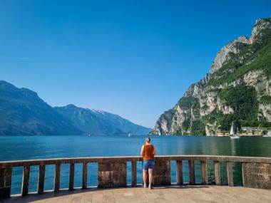 Person mit Blick auf den Gardsee umringt von der Bergwelt