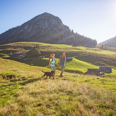 Hike of a couple with dog on the Genneralm