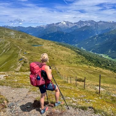 Hiker in the Gschnitztal valley with a view of the valley and mountains