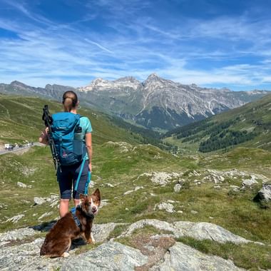 Hiker with dog and breathtaking view of the Schlügen Pass