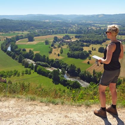 Hiker with tour map overlooking the Dordogne valley