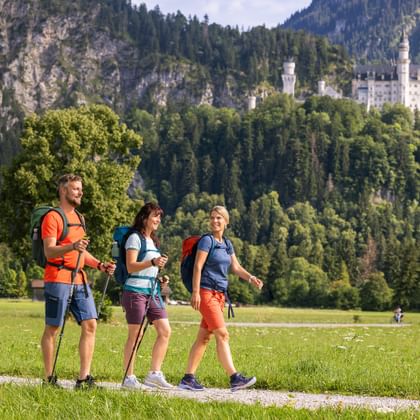 Wanderung einer Gruppe mit Blick auf Neuschwanstein