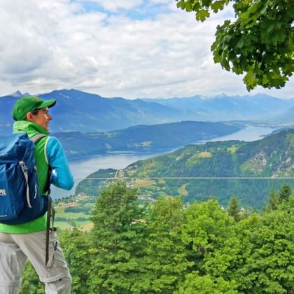 Hiker on the starry balcony near Döbriach with a view of Lake Millstättersee