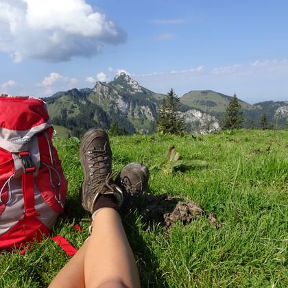 Wanderschuhe und Wanderrucksack vor Bergkulisse