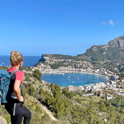 Hiker in front of the panoramic view of Port de Soller