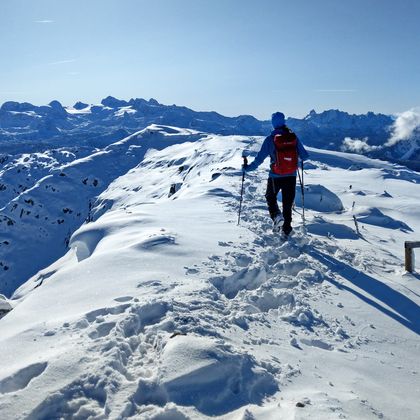 Wanderer am Berggipfel in winterlicher Landschaft