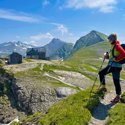 Hikers with a view of Hagener Hütte in the Gastein Valley