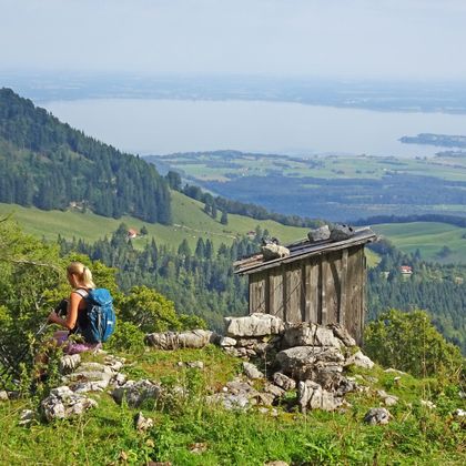 Zwei Wanderinnen auf einer Almwiese mit Blick auf den Friedenrath und denChiemsee
