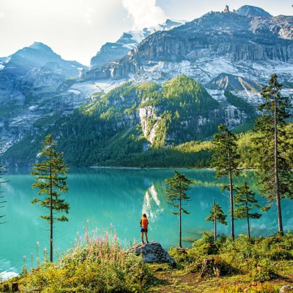 Wanderer am türkisblauen Bergsee Oeschinensee mit Bergpanorama im Hintergrund