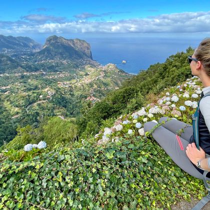 Wanderin genießt den Blick auf die Küstenlandschaft vom Aussichtspunkt Miradouro da Portela auf Madeira