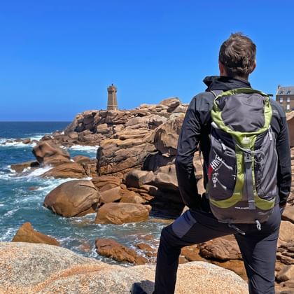 A hiker enjoys the view of the Phare de Ploumanac'h lighthouse